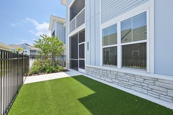A white house with a black fence and a green lawn. at The Junction at Rockledge Apartments, Rockledge, FL